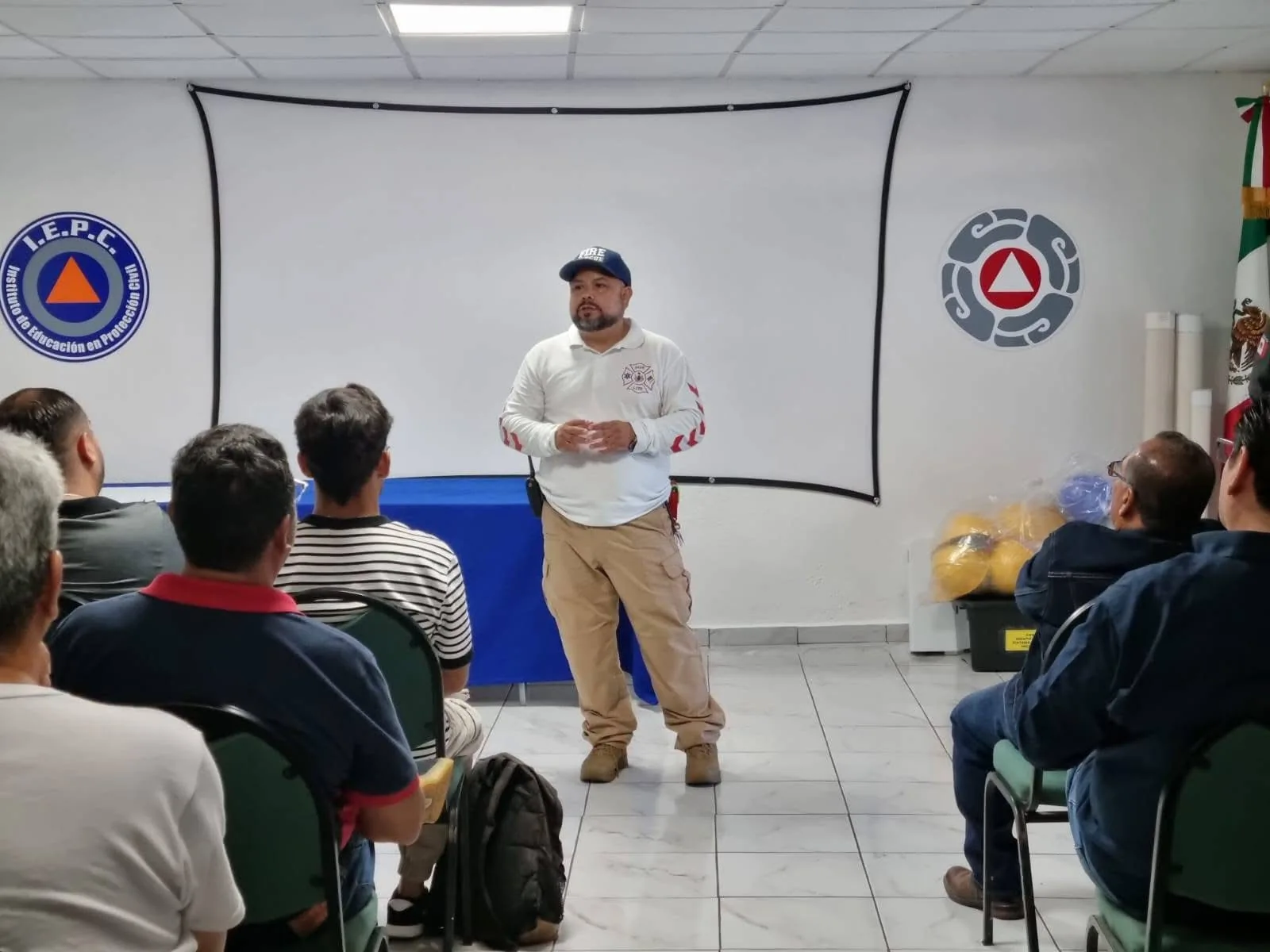 Instructor frente a asistentes en aula de protección civil